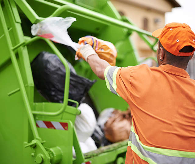 waste collector behind disposal truck