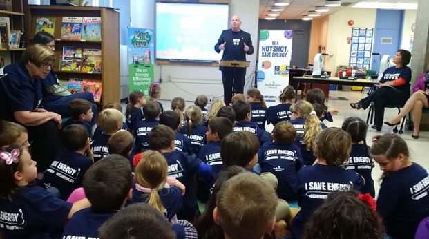 Photo of Hon. Dan Crummell, Minister Responsible for the Office of Climate Change and Energy Efficiency, speaking with Grade Two students of C.C. Loughlin school